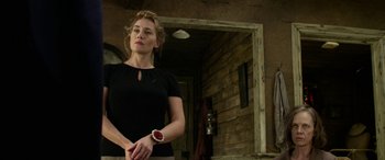 Movie still from “The Dressmaker” (2015), directed by Jocelyn Moorhouse – A woman in a black shirt is holding her arm; Medium shot, Low angle