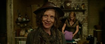 Movie still from “The Dressmaker” (2015), directed by Jocelyn Moorhouse – A woman wearing a brown hat and a scarf; Close Up shot, Over the shoulder angle