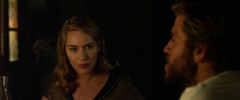 Movie still from “The Dressmaker” (2015), directed by Jocelyn Moorhouse – A woman standing next to a bearded man in a dark room; Close Up shot, Over the shoulder angle