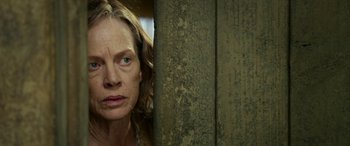 Movie still from “The Dressmaker” (2015), directed by Jocelyn Moorhouse – A woman's face in front of a wooden wall; Close Up shot, Low angle