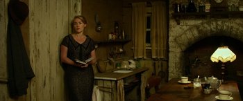 Movie still from “The Dressmaker” (2015), directed by Jocelyn Moorhouse – A woman standing in a kitchen holding a book; Medium shot, Low angle