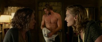 Movie still from “The Dressmaker” (2015), directed by Jocelyn Moorhouse – A man and a woman in a bathroom with another man in the background; Medium shot, Over the shoulder angle