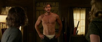 Movie still from “The Dressmaker” (2015), directed by Jocelyn Moorhouse – A man with no shirt is posing for a picture; Medium shot, Low angle