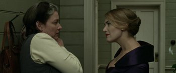 Movie still from “The Dressmaker” (2015), directed by Jocelyn Moorhouse – Two women standing next to each other in front of a building; Close Up shot, Over the shoulder angle