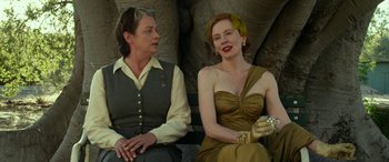 Movie still from “The Dressmaker” (2015), directed by Jocelyn Moorhouse – Two women sitting next to each other on a park bench; Medium shot, Over the shoulder angle