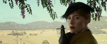 Movie still from “The Dressmaker” (2015), directed by Jocelyn Moorhouse – A woman holding a cigarette in her hand; Close Up shot, Low angle