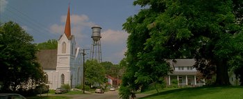 Movie still from “The Dukes of Hazzard” (2005), directed by Jay Chandrasekhar – A view of a street with a water tower in the background; Extreme Wide shot, Low angle