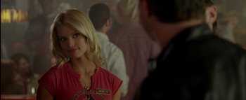 Movie still from “The Dukes of Hazzard” (2005), directed by Jay Chandrasekhar – A woman in a red shirt is standing in front of a crowd; Close Up shot, Over the shoulder angle