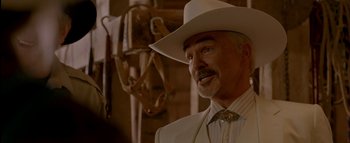 Movie still from “The Dukes of Hazzard” (2005), directed by Jay Chandrasekhar – A man in a white suit and a cowboy hat; Close Up shot, Over the shoulder angle