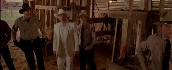 Movie still from “The Dukes of Hazzard” (2005), directed by Jay Chandrasekhar – A man and a woman standing next to each other in a barn; Wide shot, Low angle