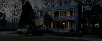 Movie still from “The Dukes of Hazzard” (2005), directed by Jay Chandrasekhar – A tow truck parked in front of a house at night; Extreme Wide shot, Low angle