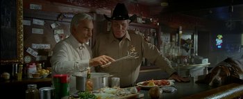 Movie still from “The Dukes of Hazzard” (2005), directed by Jay Chandrasekhar – A couple of men standing next to each other in a room; Medium shot, Low angle