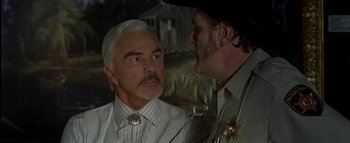 Movie still from “The Dukes of Hazzard” (2005), directed by Jay Chandrasekhar – Two men in white shirts and ties talking to each other; Close Up shot, Over the shoulder angle