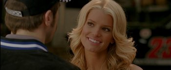 Movie still from “The Dukes of Hazzard” (2005), directed by Jay Chandrasekhar – A woman with long blonde hair smiling at a man; Close Up shot, Over the shoulder angle