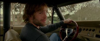 Movie still from “The Dukes of Hazzard” (2005), directed by Jay Chandrasekhar – A man sitting in the driver's seat of a car; Close Up shot, Over the shoulder angle
