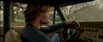 Movie still from “The Dukes of Hazzard” (2005), directed by Jay Chandrasekhar – A man sitting in the driver's seat of a car; Close Up shot, Over the shoulder angle