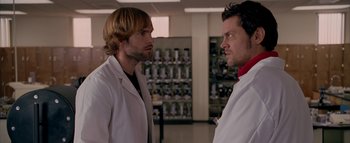 Movie still from “The Dukes of Hazzard” (2005), directed by Jay Chandrasekhar – Two men in white lab coats standing next to each other; Medium shot, Over the shoulder angle