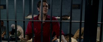 Movie still from “The Dukes of Hazzard” (2005), directed by Jay Chandrasekhar – A man sitting in front of a jail cell; Medium shot, Over the shoulder angle