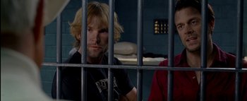 Movie still from “The Dukes of Hazzard” (2005), directed by Jay Chandrasekhar – A man sitting behind bars in a jail cell; Close Up shot, Over the shoulder angle