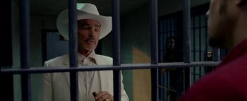 Movie still from “The Dukes of Hazzard” (2005), directed by Jay Chandrasekhar – A man in a white suit and a white cowboy hat; Medium shot, Over the shoulder angle