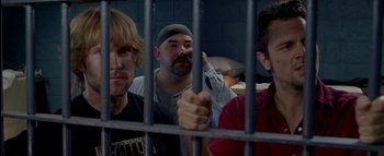 Movie still from “The Dukes of Hazzard” (2005), directed by Jay Chandrasekhar – A group of people behind a metal fence; Close Up shot, Low angle