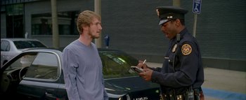 Movie still from “The Dukes of Hazzard” (2005), directed by Jay Chandrasekhar – A police officer writing a ticket for a man; Medium shot, Over the shoulder angle