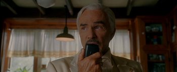 Movie still from “The Dukes of Hazzard” (2005), directed by Jay Chandrasekhar – An older man holding a cell phone up to his mouth; Close Up shot, Low angle