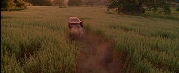 Movie still from “The Dukes of Hazzard” (2005), directed by Jay Chandrasekhar – A truck is driving through a field of tall grass; Extreme Wide shot, High angle