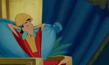 Movie still from “The Emperor's New Groove” (2000), directed by Mark Dindal – A cartoon of a man sitting on a chair; Medium shot, Over the shoulder angle