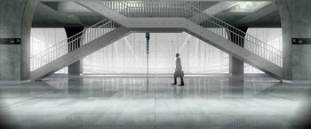 Movie still from “The End of the Tour” (2015), directed by James Ponsoldt – A man in a white suit is standing in front of a staircase; Extreme Wide shot, Low angle