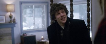 Movie still from “The End of the Tour” (2015), directed by James Ponsoldt – A man with curly hair sitting in front of a window; Close Up shot, Over the shoulder angle