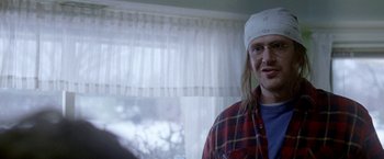 Movie still from “The End of the Tour” (2015), directed by James Ponsoldt – A man with long blonde hair wearing glasses and a white bandanna; Close Up shot, Over the shoulder angle