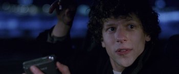 Movie still from “The End of the Tour” (2015), directed by James Ponsoldt – A person holding a cell phone; Close Up shot, Over the shoulder angle