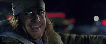 Movie still from “The End of the Tour” (2015), directed by James Ponsoldt – A person wearing glasses and a hat; Close Up shot, Low angle