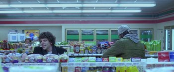 Movie still from “The End of the Tour” (2015), directed by James Ponsoldt – Two people in a grocery store looking at food items; Medium shot, Over the shoulder angle