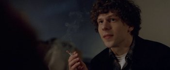 Movie still from “The End of the Tour” (2015), directed by James Ponsoldt – A man smoking a cigarette while sitting in a room; Close Up shot, Over the shoulder angle