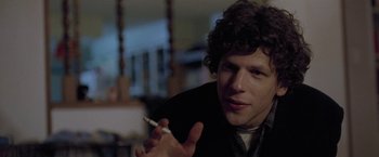 Movie still from “The End of the Tour” (2015), directed by James Ponsoldt – A man holding a cigarette in his right hand; Close Up shot, Over the shoulder angle