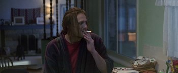 Movie still from “The End of the Tour” (2015), directed by James Ponsoldt – A man with long hair is smoking a cigarette; Medium shot, Over the shoulder angle