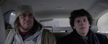 Movie still from “The End of the Tour” (2015), directed by James Ponsoldt – Two people sitting in the back seat of a car; Close Up shot, Over the shoulder angle