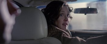 Movie still from “The End of the Tour” (2015), directed by James Ponsoldt – A woman sitting in the back seat of a car; Close Up shot, Over the shoulder angle