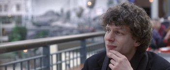 Movie still from “The End of the Tour” (2015), directed by James Ponsoldt – A man with curly hair sitting on a bench; Close Up shot, Over the shoulder angle