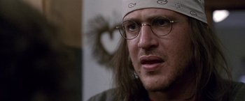 Movie still from “The End of the Tour” (2015), directed by James Ponsoldt – A person wearing glasses and a hat; Close Up shot, Over the shoulder angle