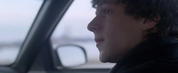 Movie still from “The End of the Tour” (2015), directed by James Ponsoldt – A person in a car looking out of the window; Close Up shot, Over the shoulder angle