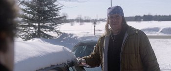 Movie still from “The End of the Tour” (2015), directed by James Ponsoldt – A man standing in front of a car covered in snow; Medium shot, Over the shoulder angle