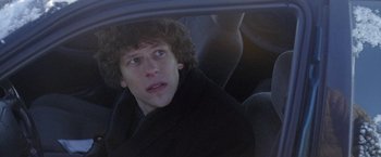 Movie still from “The End of the Tour” (2015), directed by James Ponsoldt – A man sitting in the back seat of a car; Close Up shot, Over the shoulder angle