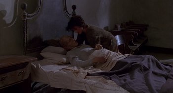 Movie still from “The English Patient” (1996), directed by Anthony Minghella – A man laying in a bed with a woman; Medium shot, High angle