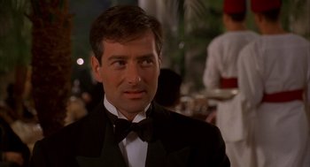 Movie still from “The English Patient” (1996), directed by Anthony Minghella – A person wearing a suit and a bow tie; Close Up shot, Over the shoulder angle