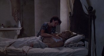 Movie still from “The English Patient” (1996), directed by Anthony Minghella – A man laying in a bed with a woman; Medium shot, High angle