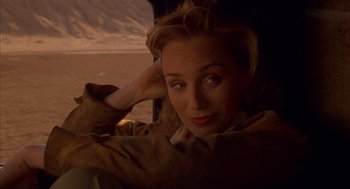 Movie still from “The English Patient” (1996), directed by Anthony Minghella – A woman sitting in a car with her hand on her head; Close Up shot, Over the shoulder angle
