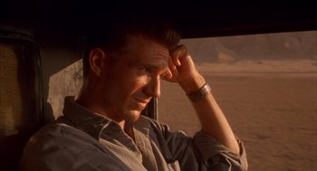 Movie still from “The English Patient” (1996), directed by Anthony Minghella – A person sitting in a car; Close Up shot, Low angle
